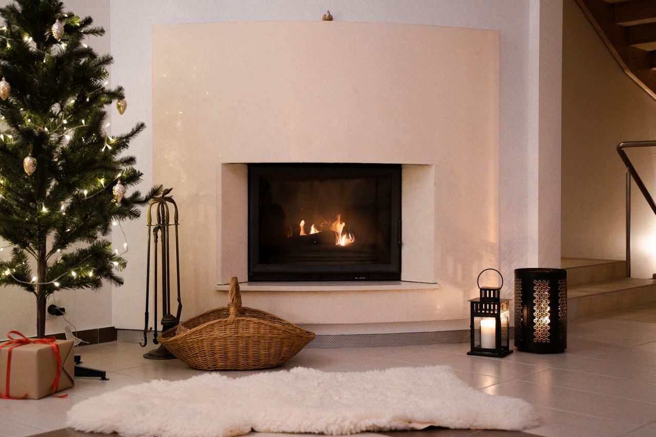 Contact Warm Christmas atmosphere in a living room with a decorated tree and a glowing fireplace.